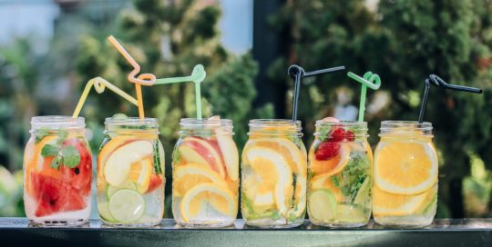 Fruit and water in jars with straws